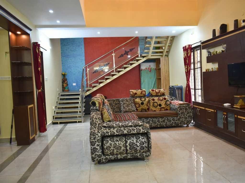 Living hall of the 3 BHK villa with sofas and internal staircase
